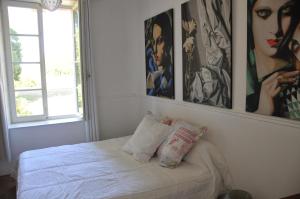 - une chambre avec un lit et des photos sur le mur dans l'établissement La Terrasse de L'Orangerie du Château - Art Nouveau - GITE 2 Personnes, à Brain-sur-Allonnes