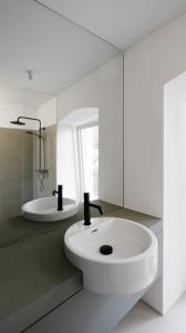 a white bathroom with a sink and a tub at CHARMANTES APARTMENT im Herzen von Linz in Linz