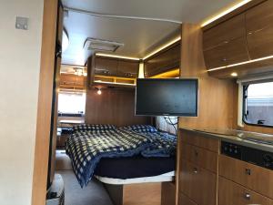 ein kleines Schlafzimmer mit einem Bett und einem Flachbild-TV in der Unterkunft Zillerglückhütte - 5 Sterne Camping Aufenfeld in Aschau