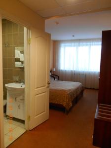 a bedroom with a bed and a dresser at Pik Hotel in Ryazan
