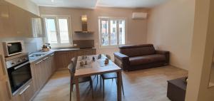 a kitchen with a table and a couch in a room at La Casa di Anna in Gargnano