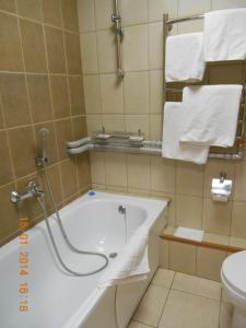 a white bath tub sitting next to a white toilet at Pik Hotel in Ryazan