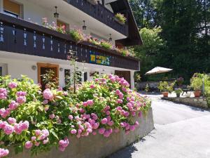 a bunch of pink flowers in front of a building at Accommodation Destina, LAKE BOHINJ in Bohinj