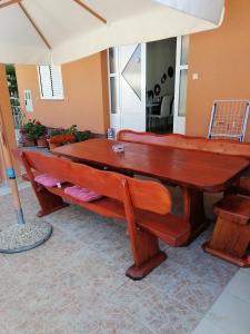 ビオグラード・ナ・モルにあるApartments Perlaの大きな木製テーブルとベンチが備わる客室です。