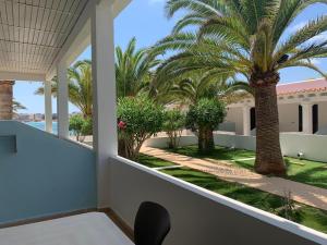 a view from the balcony of a resort with palm trees at Hotel Roca Bella in Es Pujols
