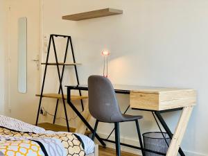 een slaapkamer met een bureau en een stoel naast een bed bij Grand appartement plein centre proche bus et gare in Valence