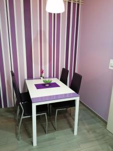 uma mesa de jantar com cadeiras e uma mesa roxa e branca em Apartments Perla em Biograd na Moru