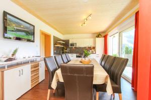 eine Küche mit einem Holztisch und schwarzen Stühlen in der Unterkunft Appartementhaus Casamarai in Saalbach-Hinterglemm