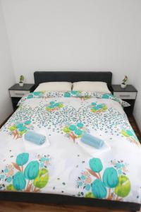 łóżko z narzutą z kwiatami w obiekcie Apartman Vlačić w mieście Trebinje