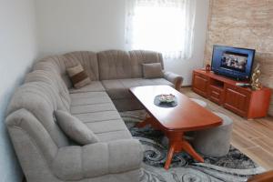 salon z kanapą i stołem w obiekcie Apartman Vlačić w mieście Trebinje