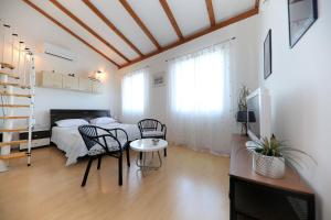 a bedroom with a bed and a table and chairs at Puntamika studio in Zadar