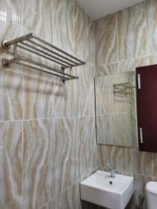 a bathroom with a sink and a mirror at CD Seaview Apartment in Kuah