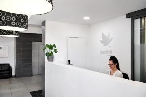 a woman sitting at a counter in a room at Punthill Oakleigh in Oakleigh