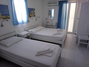 a hotel room with two beds and a television at Nicolas Antiparos in Antiparos