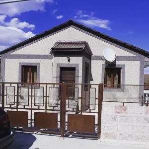 une maison blanche avec une clôture devant elle dans l'établissement Cottage Tsaghkadzor, à Tsaghkadzor