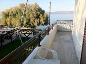 een balkon met een stoel en uitzicht op het water bij Chris Studios & Apartments in Lechaio