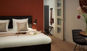 a bedroom with a bed and a chair at Boutique Hotel Beekhuizen in Velp