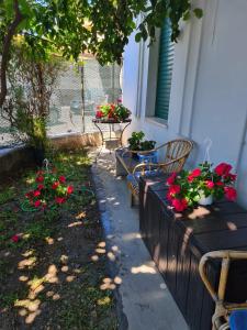 un porche con 2 sillas y una mesa con flores en La casa di Alvy, en Pescara