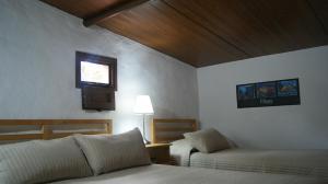 1 dormitorio con cama, sofá y ventana en Casas Del Monte II, en Valverde