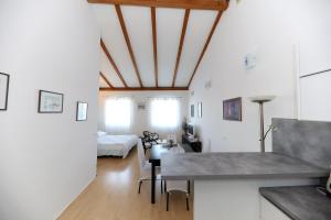 a kitchen and living room with white walls and a table at Puntamika studio in Zadar