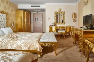 Hotel Gold في إسكوبية: غرفة نوم بسرير ومكتب ومرآة