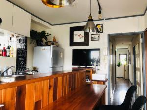 a kitchen with a wooden counter and a refrigerator at 一棟貸しの海宿 Kamakura SUN&BREEZE in Kamakura