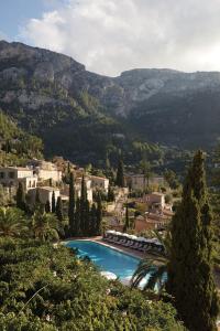 uma piscina numa aldeia com montanhas ao fundo em La Residencia, A Belmond Hotel, Mallorca em Deia