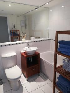 a bathroom with a toilet and a sink and a tub at Glasgow City Centre Waterfront Apartment in Glasgow