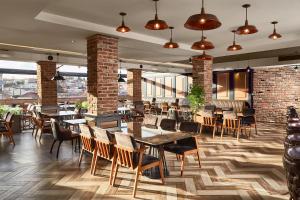 a restaurant with tables and chairs and brick walls at Hotel Gold in Skopje
