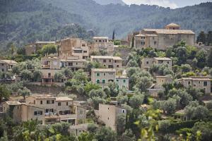 La Residencia, A Belmond Hotel, Mallorca في دِيّا: قرية على تلة فيها بيوت واشجار