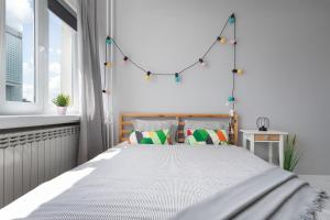um quarto com uma cama branca com luzes por cima em Bagno Cozy Studio II em Varsóvia