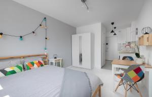 um quarto branco com uma cama e uma secretária em Bagno Cozy Studio II em Varsóvia