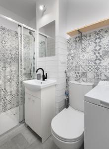 a bathroom with a toilet and a sink and a shower at Bagno Cozy Studio II in Warsaw