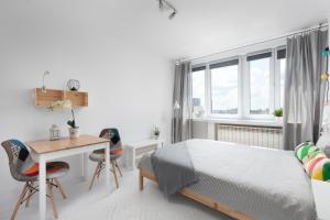 a bedroom with a bed and a table and chairs at Bagno Cozy Studio II in Warsaw