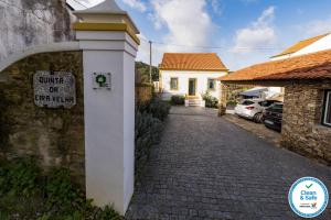 un cartel en una pared junto a un camino de ladrillo en Quinta da Eira Velha, en Aldeia do Mato