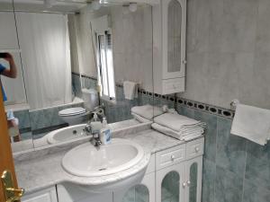 a white bathroom with a sink and a mirror at Apartamento CUATTRO vut 47-169 wifi in Valladolid