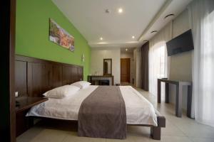 a bedroom with a large bed with a green wall at Gaudi stylish hotel in Odesa