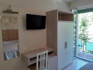 ein Wohnzimmer mit einem TV an einer Wand mit einer Tür in der Unterkunft Hotel Ambra in Cesenatico