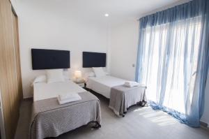 1 Schlafzimmer mit 2 Betten und einem großen Fenster in der Unterkunft Villas Guzman - Grandiosa in Calpe