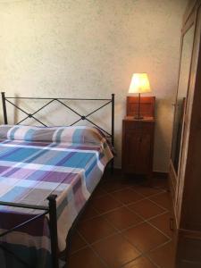ein Schlafzimmer mit einem Bett und einer Lampe auf einem Tisch in der Unterkunft Agriturismo Il Poggio in Casale Marittimo