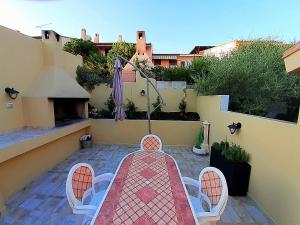 einen Tisch und Stühle auf einer Terrasse mit Sonnenschirm in der Unterkunft Casa Arega in Càbras