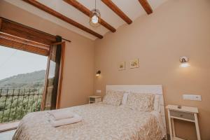 Un dormitorio con una cama y una ventana grande. en Casa Etxalde, en Camprodon