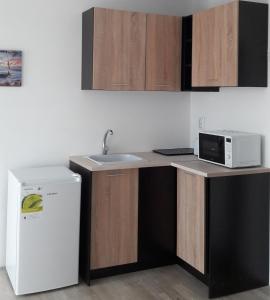 a kitchen with a sink and a microwave at Casa Del Mar in Primorsko