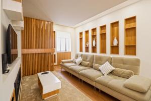 a living room with a couch and a tv at Ribeira Riverhouse - City Centre Duplex with Terrace in Viana do Castelo