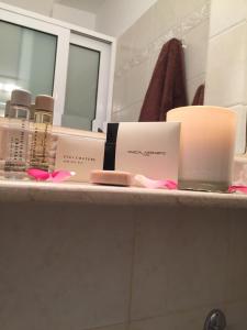a bathroom counter with products on it in front of a mirror at Moireas Apartments in Akrogiali