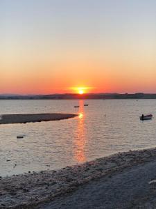 a sunset over a body of water with a beach at Thealassa in Kalliópi