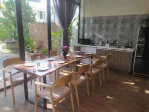 a dining room with a table and chairs and a kitchen at The 1954 House in Da Lat