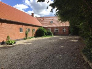 a brick building with a driveway in front of it at Varde Bed and Kitchen in Varde