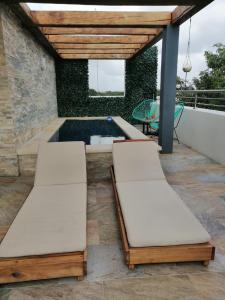 two beds on a patio with a swimming pool at Azura Boutique Hotel in Tulum