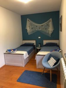 a bedroom with two beds and a blue accent wall at Villa Santoma Hill in Koper +57 photos